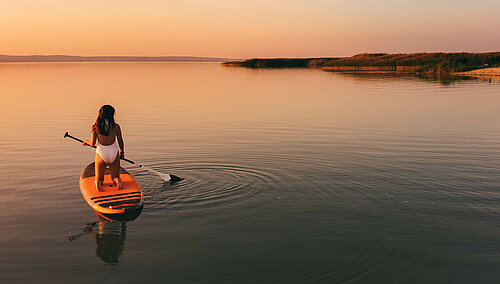 SUP ©TVB Podersdorf am See, Die schier endlosen Weiten des Steppensees lassen sich am besten auf dem Stand Up Paddle Board erkunden